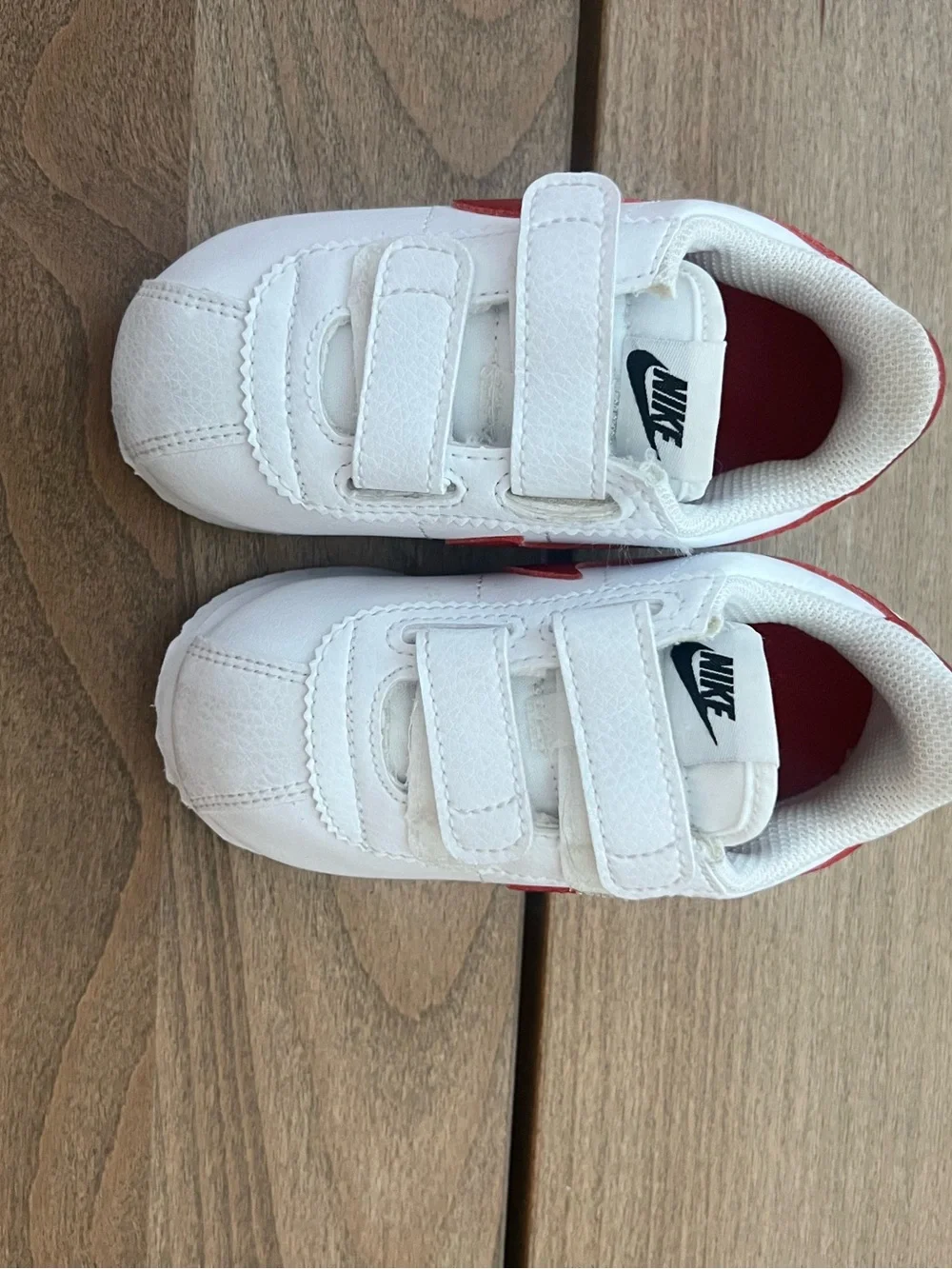 Nike Kids White Sneakers with Red Swoosh and Blue Sole Accent